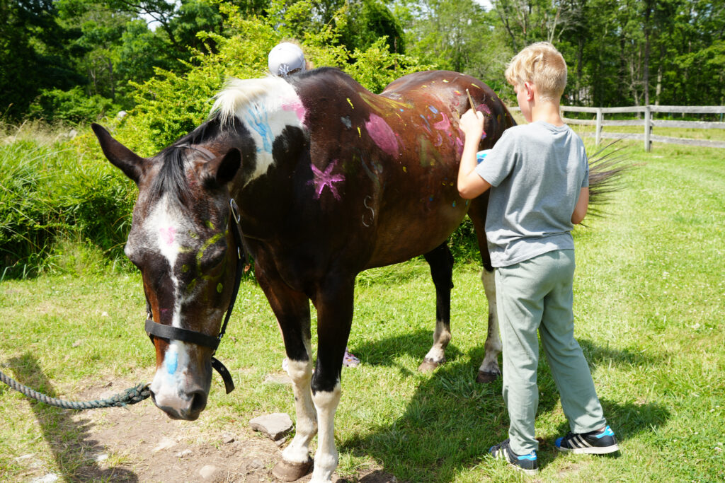boy painting a horse at camp lakota