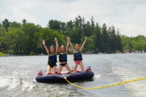 Campers riding an inflatable tube on Masten Lake during Camp Lakota waterfront activities