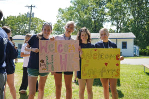 Counselors with welcome signs for campers at Camp Lakota